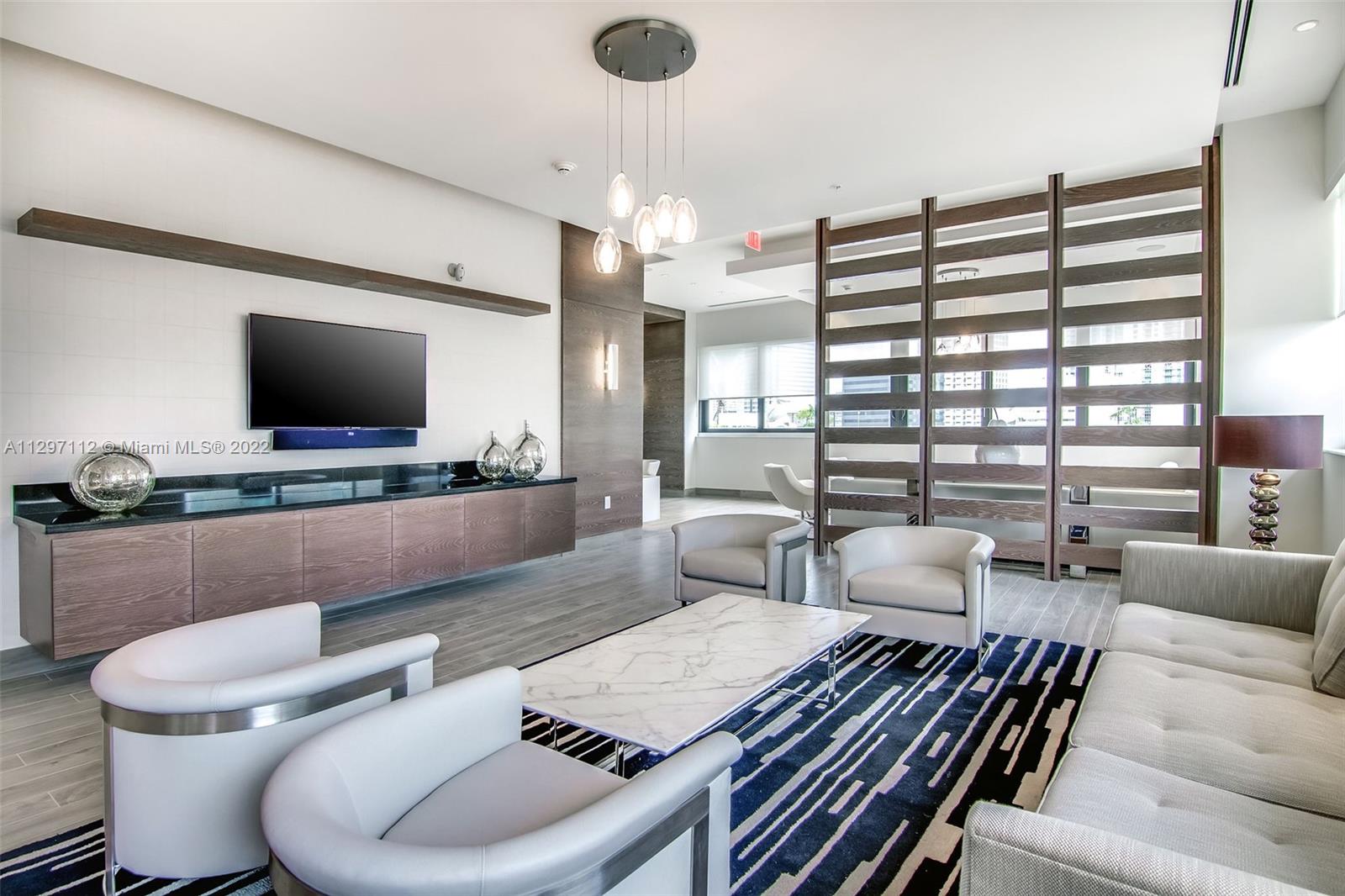 999 Southwest 1st Avenue, Unit 2717 Miami, FL 33130 - Photo 41 of 93 a living room with furniture a flat screen tv and a large window