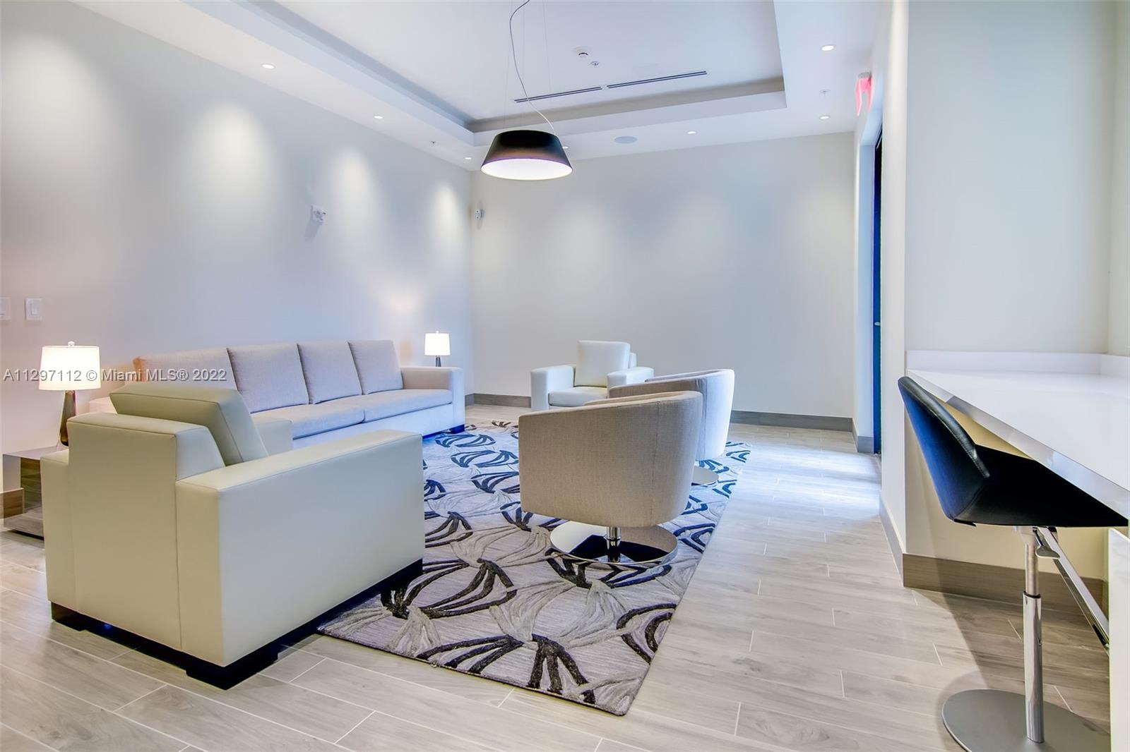 999 Southwest 1st Avenue, Unit 2717 Miami, FL 33130 - Photo 53 of 93 a living room with a couch and a table with wooden floor