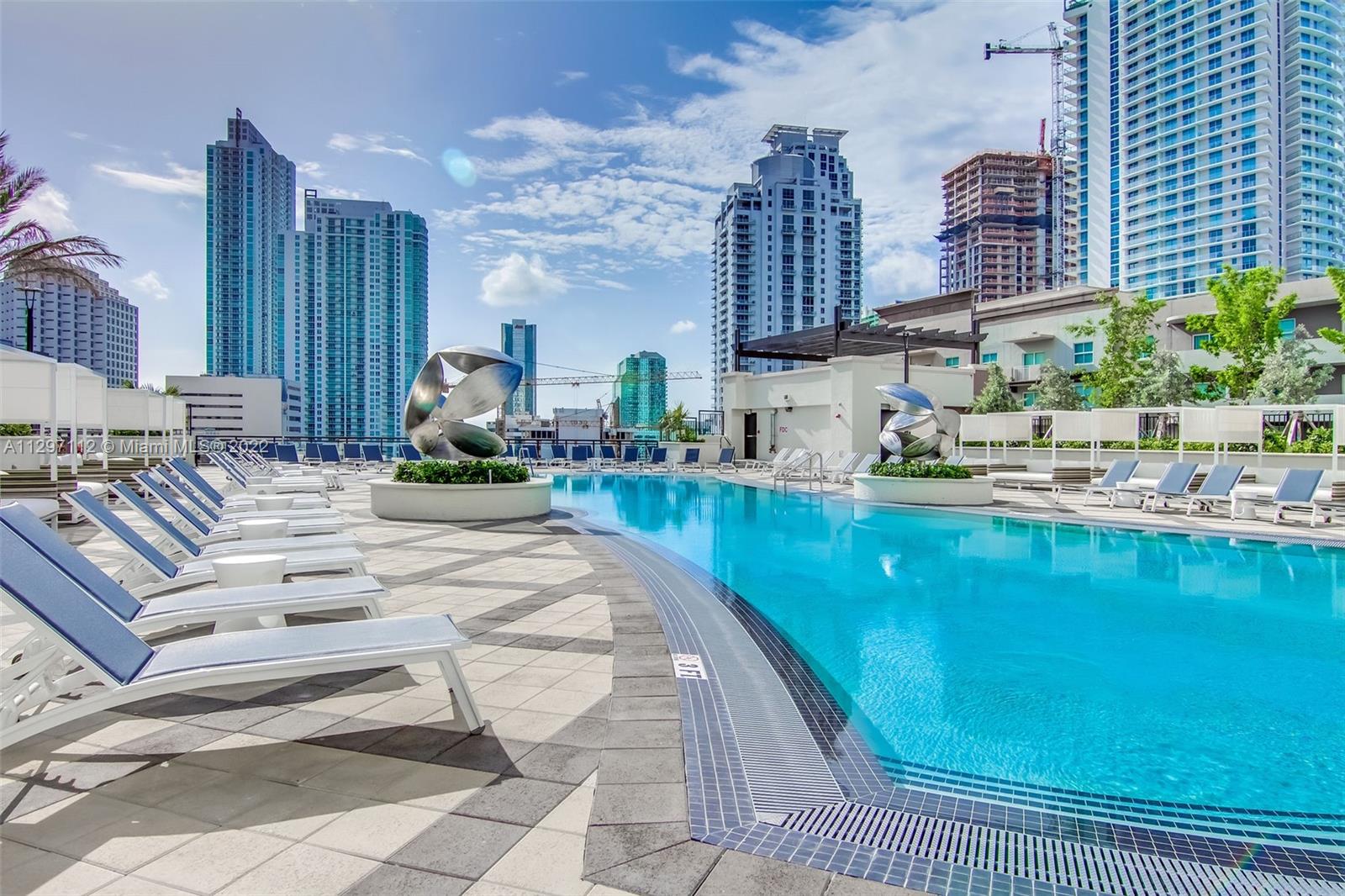 999 Southwest 1st Avenue, Unit 2717 Miami, FL 33130 - Photo 65 of 93 a swimming pool with outdoor seating and yard