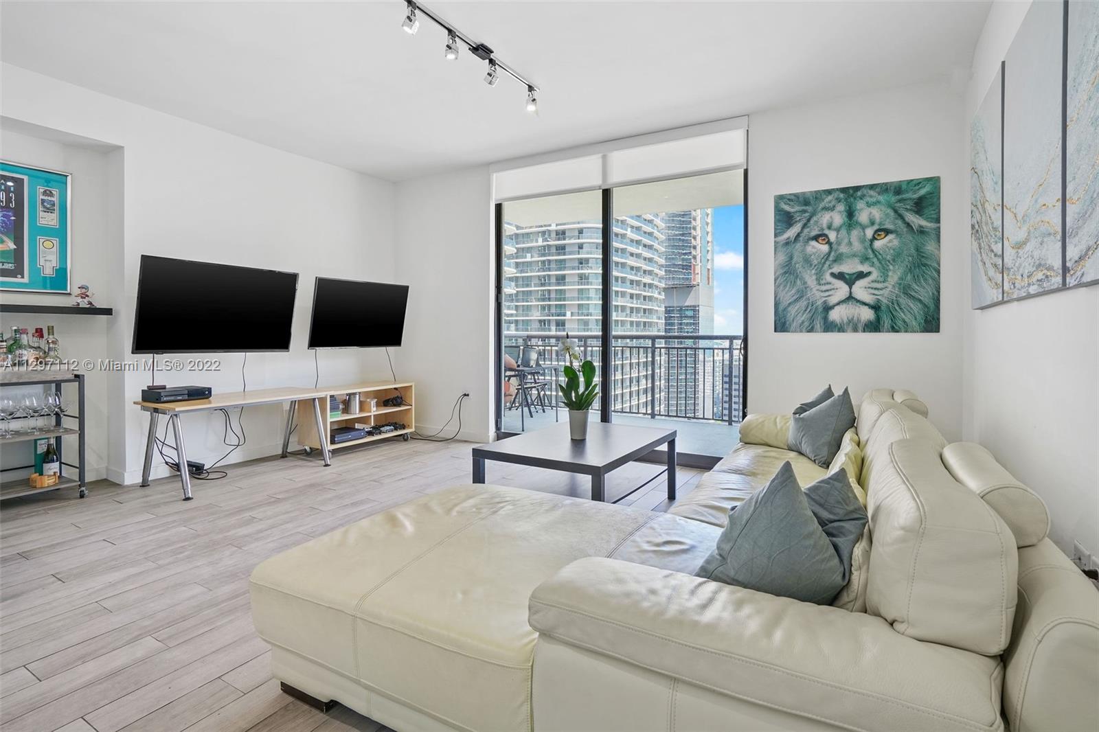 999 Southwest 1st Avenue, Unit 2717 Miami, FL 33130 - Photo 9 of 93 a living room with furniture and a flat screen tv