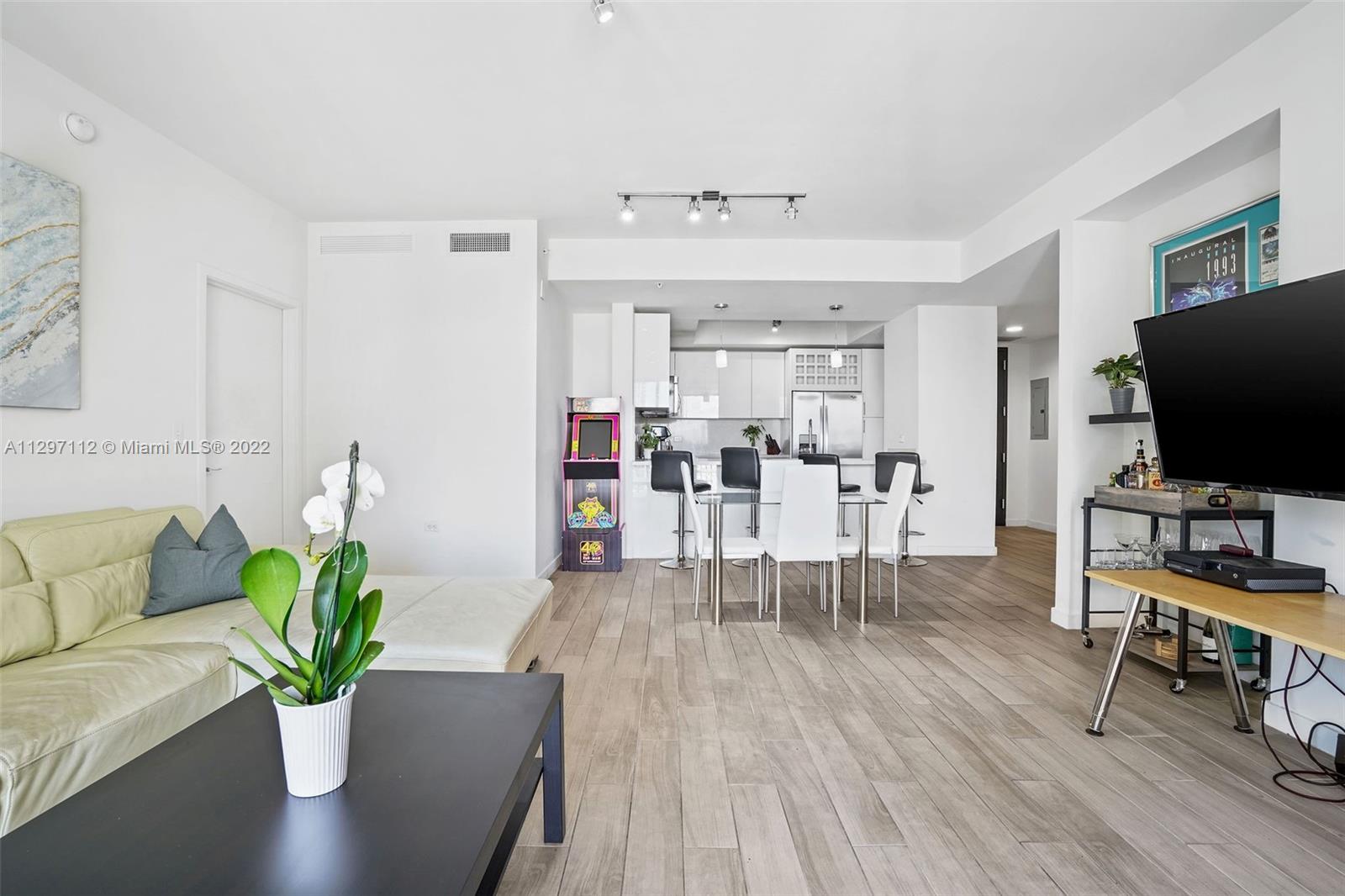 999 Southwest 1st Avenue, Unit 2717 Miami, FL 33130 - Photo 10 of 93 a living room with furniture potted plant and a flat screen tv