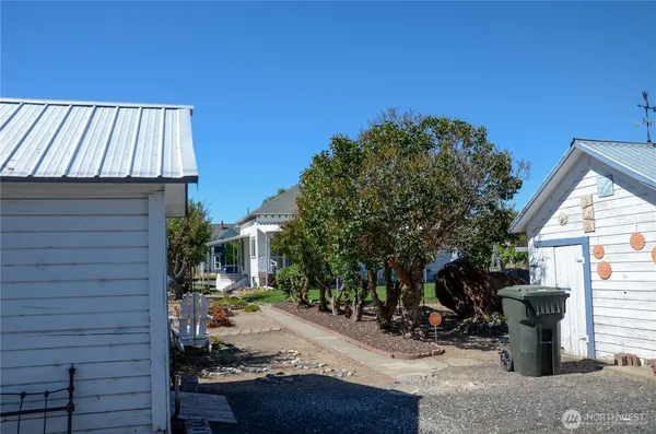 a view of a patio with table and chairs and potted plants with wooden fence