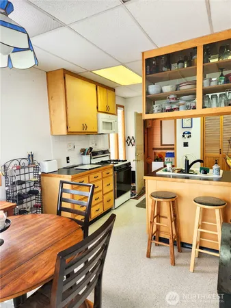 a kitchen with kitchen island a stove a table and chairs in it