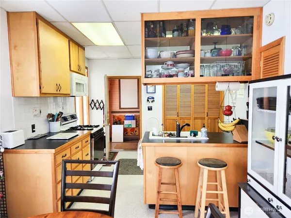 a kitchen with a sink stove and chairs