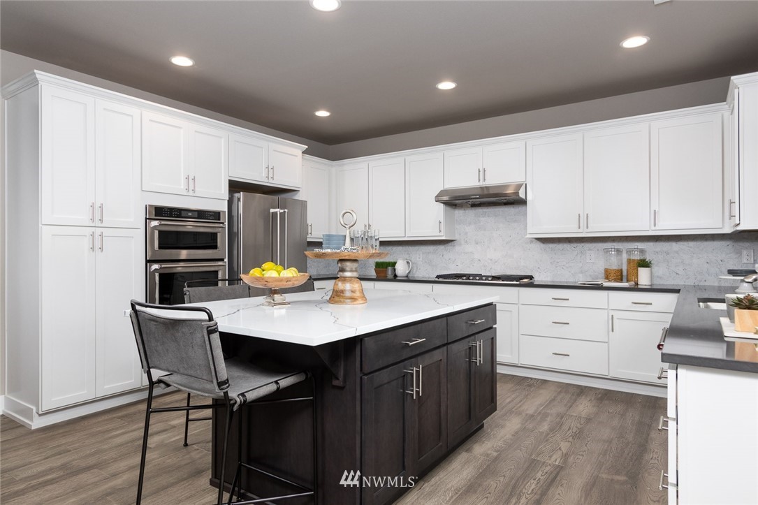 6515 Southeast 2nd Place Renton, WA 98059 - Photo 8 of 29 a kitchen with a sink stainless steel appliances and white cabinets
