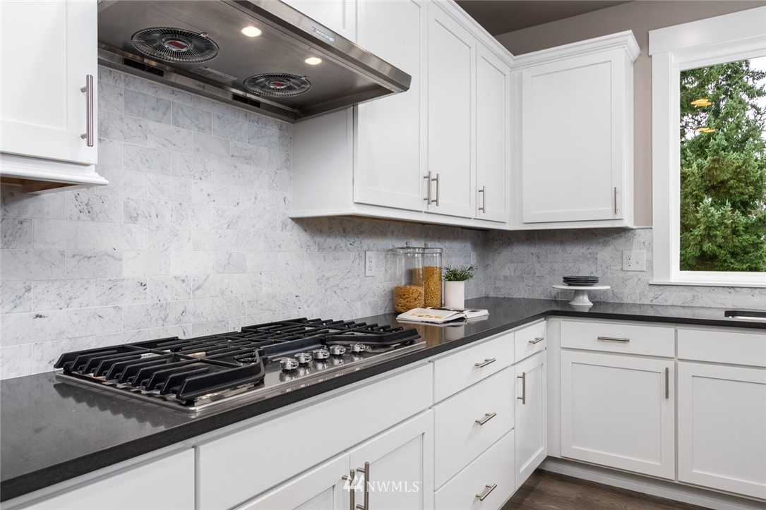 6515 Southeast 2nd Place Renton, WA 98059 - Photo 9 of 29 a kitchen with granite countertop white cabinets and appliances