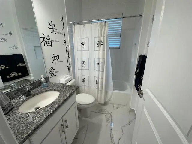 a bathroom with a granite countertop sink toilet and shower