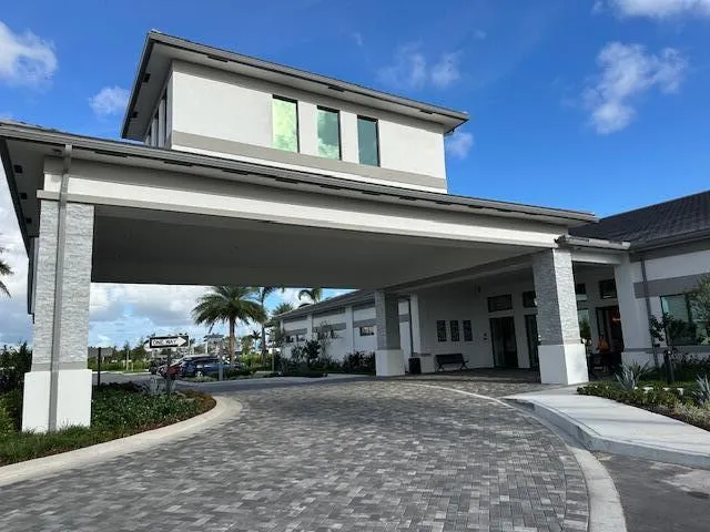a view of a house with large windows and a yard