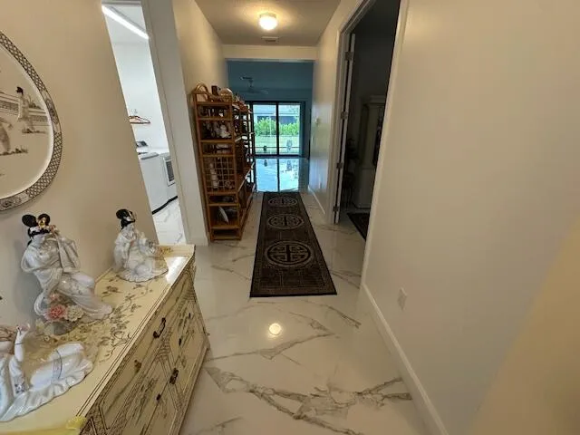 a view of a hallway to a livingroom with furniture