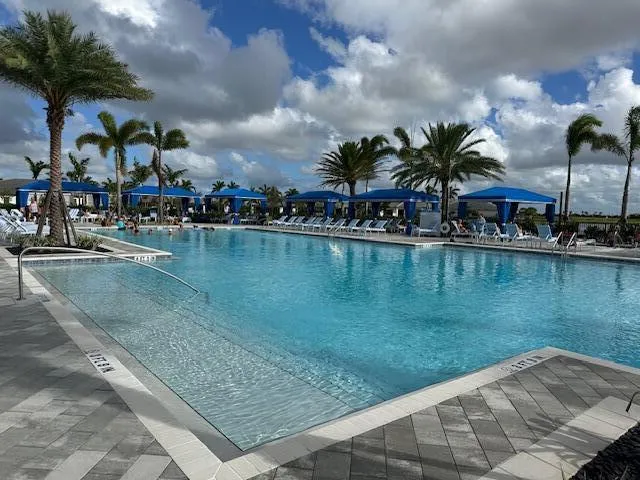 a view of a swimming pool with a table and chairs under an umbrella