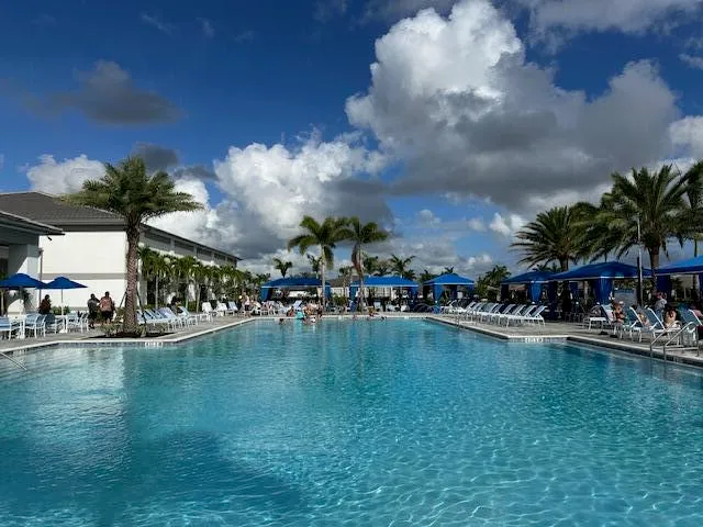 a kitchen with lots of white furniture a dining table and chairs