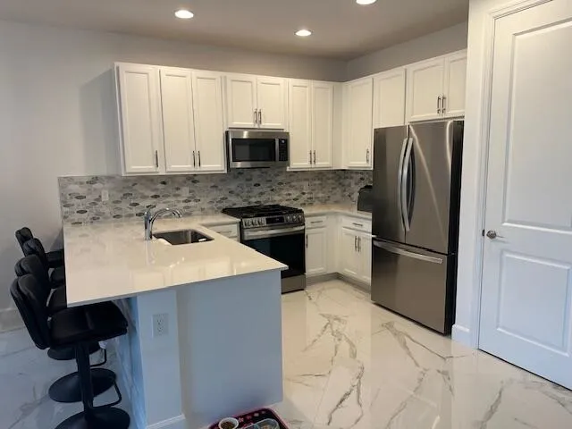 a kitchen with stainless steel appliances a refrigerator sink stove microwave and cabinets