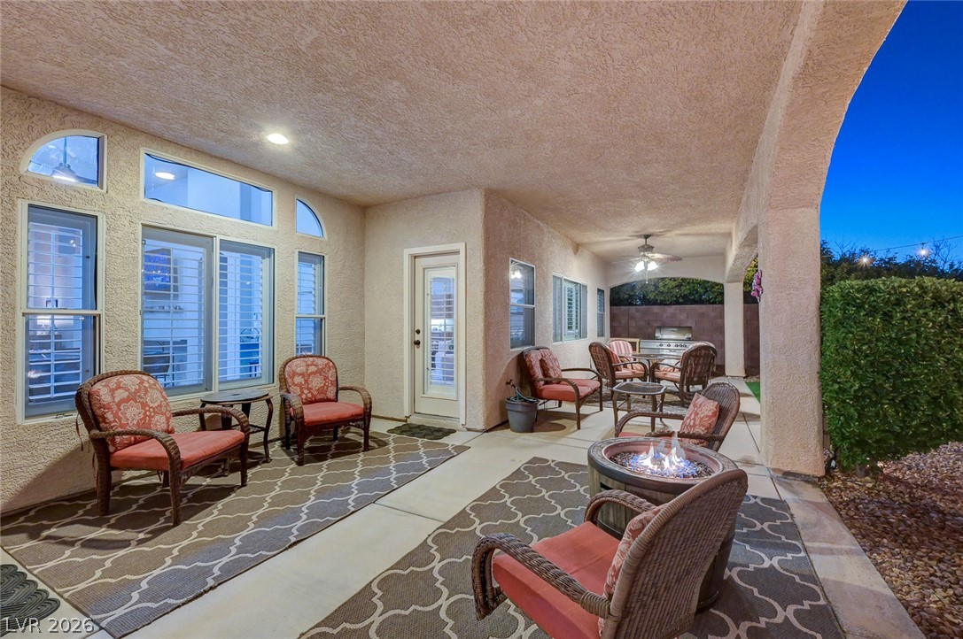1604 Cattle Ranch Place Henderson, NV 89002 - Photo 88 of 99 An inviting covered patio features ample seating, a fire pit, and an outdoor kitchen for alfresco entertaining.