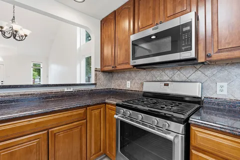 a kitchen with stainless steel appliances granite countertop a refrigerator and a sink