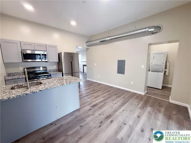 a kitchen with stainless steel appliances a refrigerator and a stove top oven