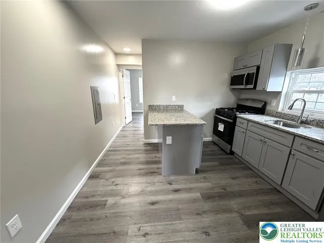 a kitchen with stainless steel appliances granite countertop a sink stove and refrigerator
