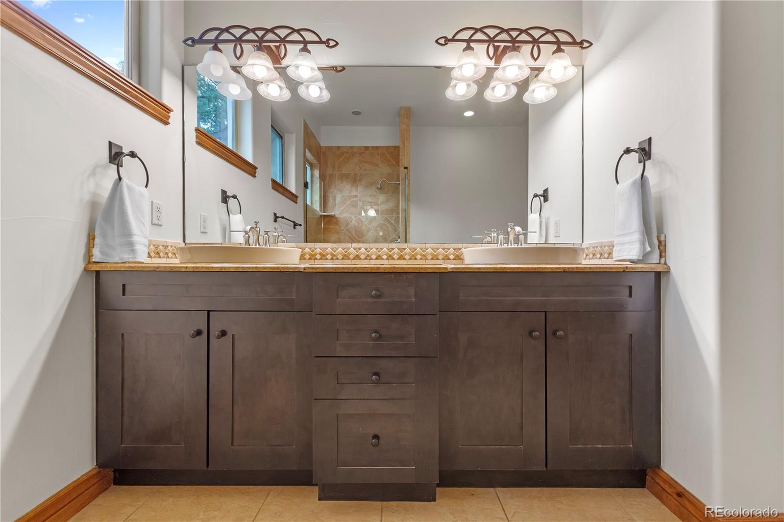 590 Cumberland Road Larkspur, CO 80118 - Photo 17 of 47 a bathroom with a sink vanity and a mirror