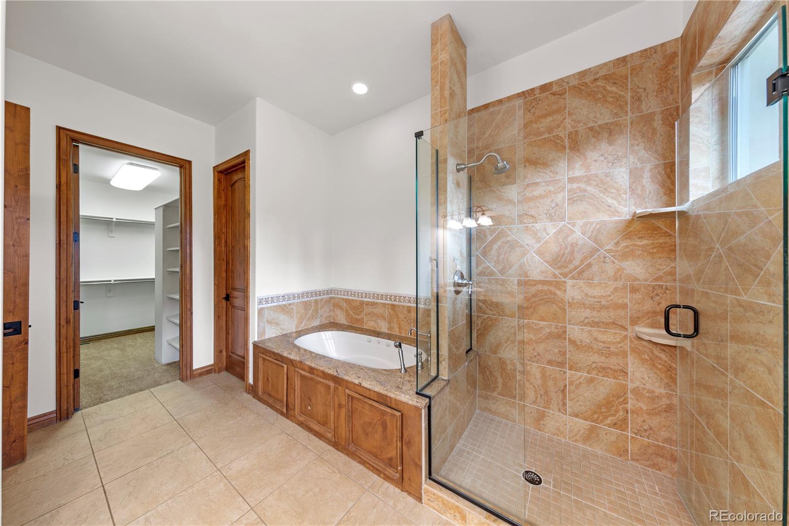 590 Cumberland Road Larkspur, CO 80118 - Photo 19 of 47 a bathroom with a tub shower and mirror