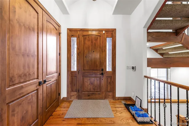 a view of a hallway with wooden floor and door
