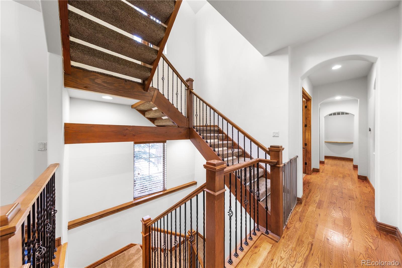590 Cumberland Road Larkspur, CO 80118 - Photo 21 of 47 a view of staircase with wooden floor and a chandelier