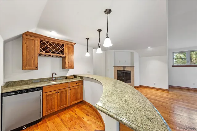 a kitchen with granite countertop a sink a stove and cabinets