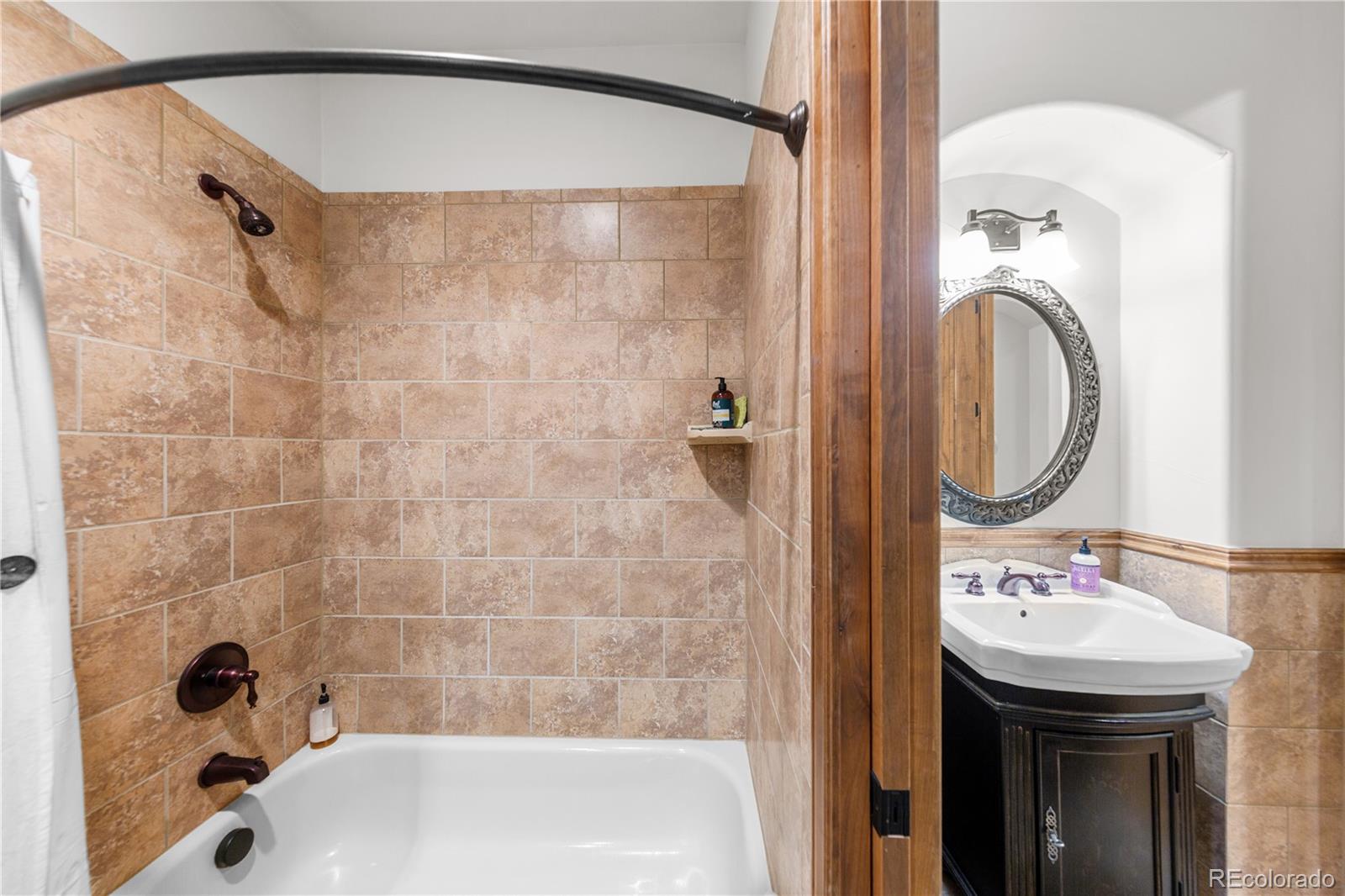 590 Cumberland Road Larkspur, CO 80118 - Photo 36 of 47 a bathroom with a sink a mirror and a bathtub