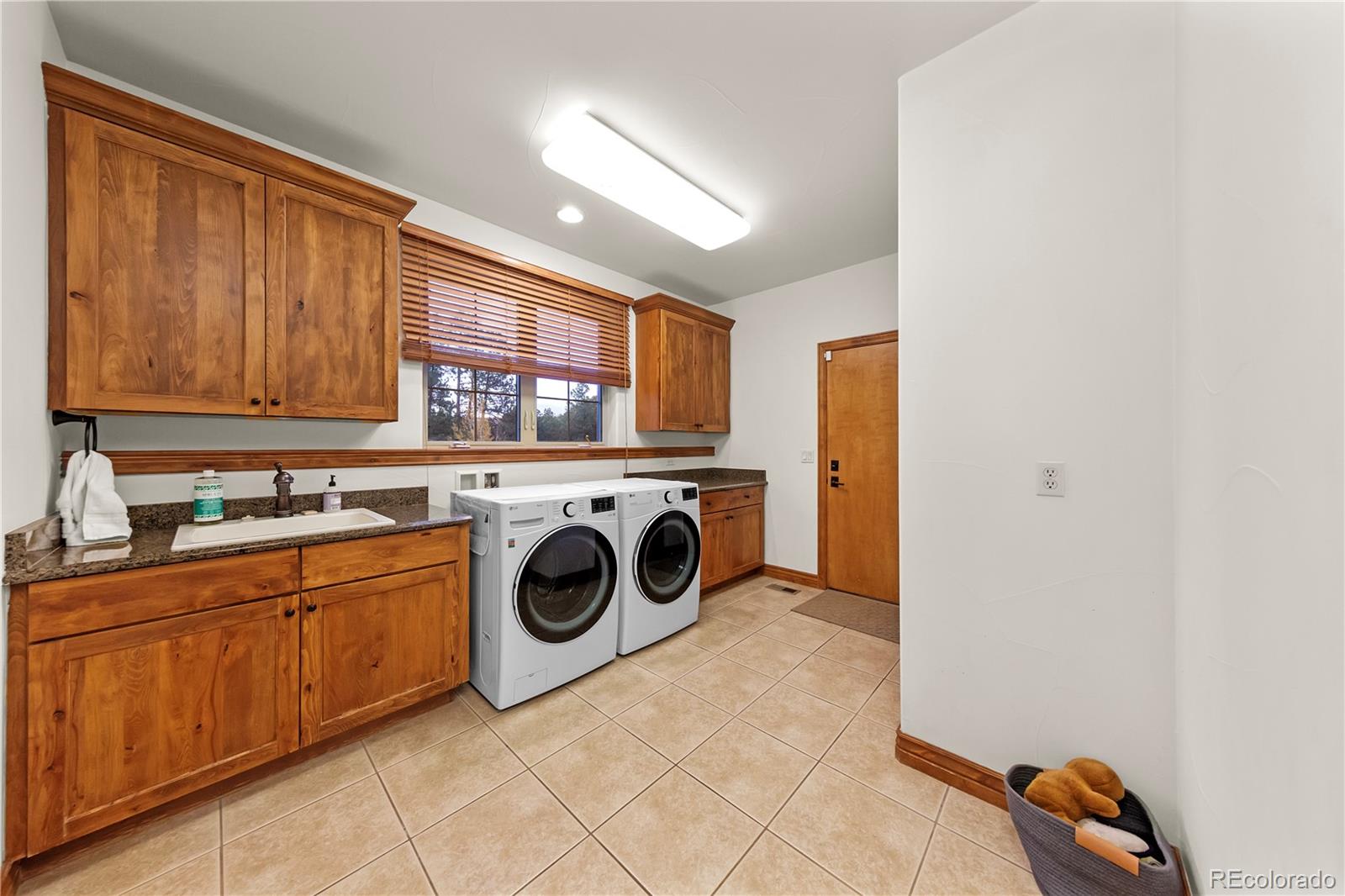 590 Cumberland Road Larkspur, CO 80118 - Photo 38 of 47 a utility room with sink dryer and washer