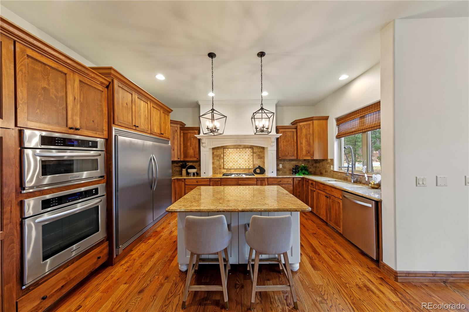 590 Cumberland Road Larkspur, CO 80118 - Photo 9 of 47 a kitchen with cabinets a counter space stainless steel appliances and a chandelier