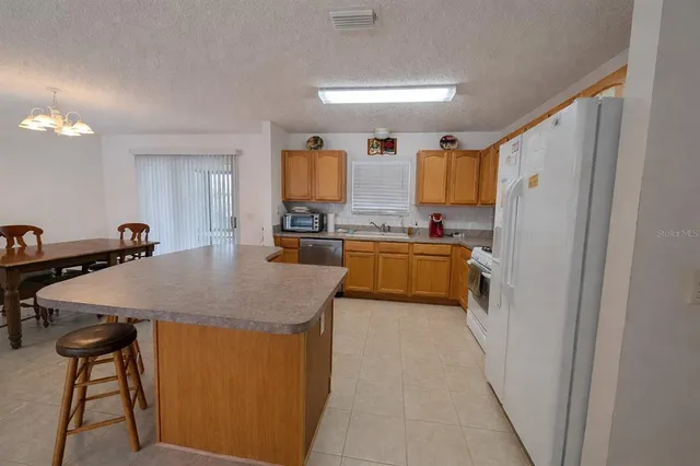 a kitchen with stainless steel appliances granite countertop a sink a refrigerator and a stove