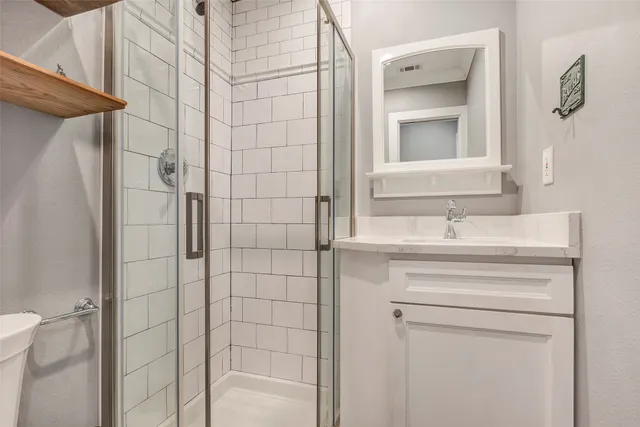 a bathroom with a shower sink and mirror