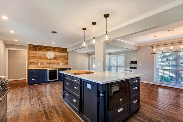 a kitchen with a stove and a wooden floor