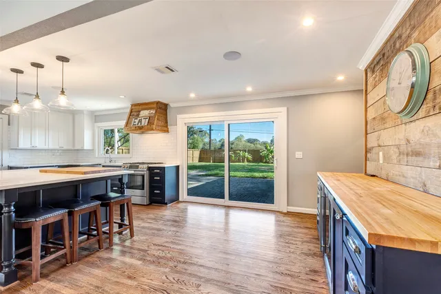 a kitchen with stainless steel appliances granite countertop a stove and a wooden floors