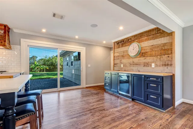a open kitchen with wooden floors and a large window