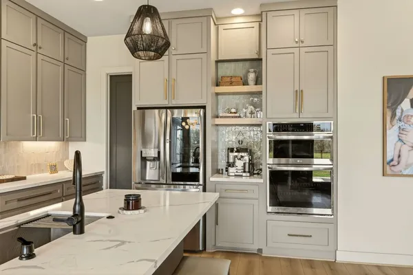 a kitchen with stainless steel appliances granite countertop a sink and a refrigerator