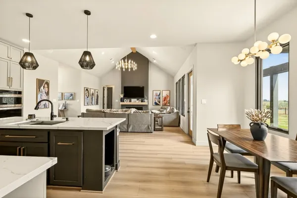 a kitchen with stainless steel appliances granite countertop a sink a stove and a wooden floors