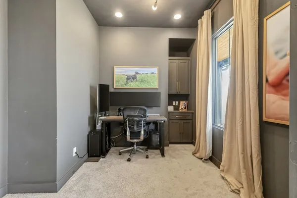 a view of a workspace with furniture and a window