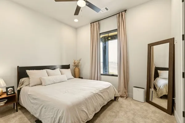 a bedroom with a large bed and a chandelier