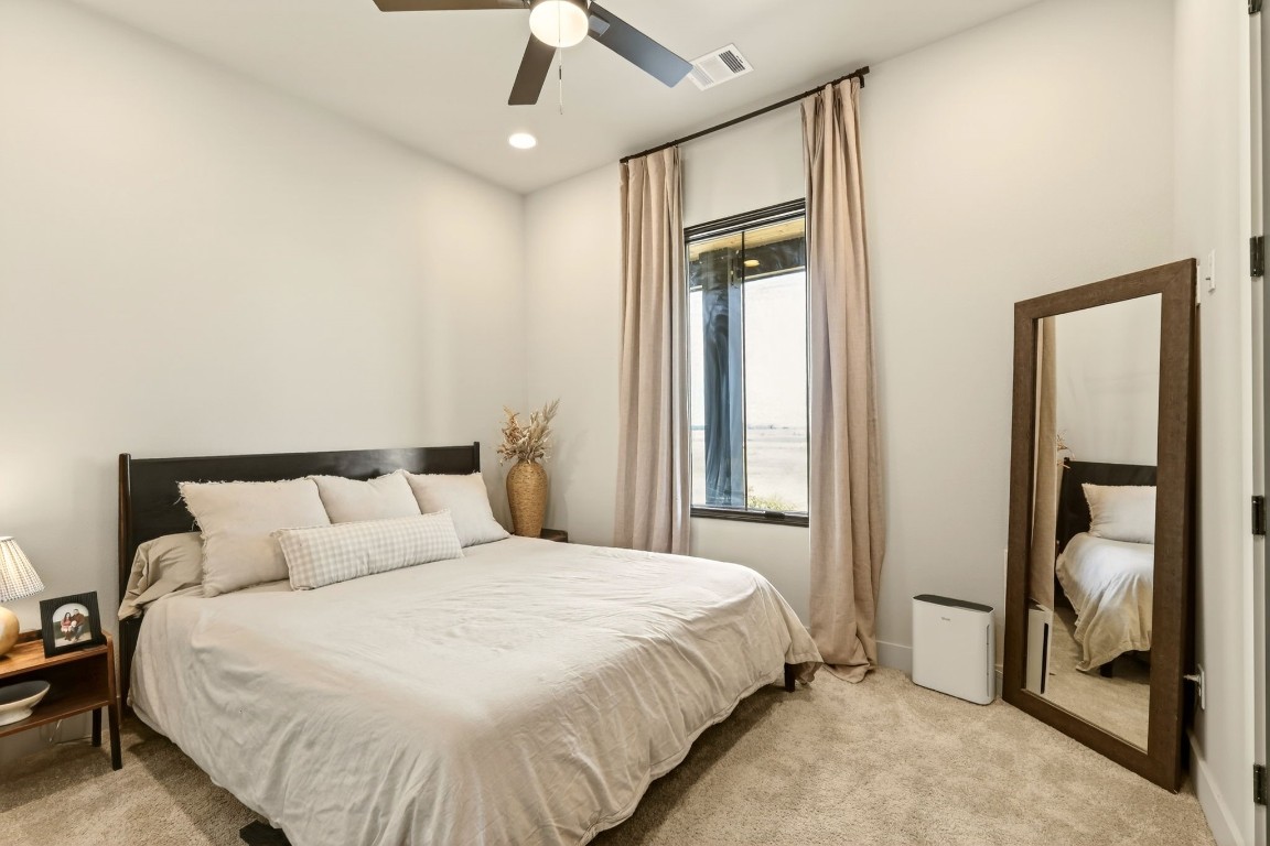 115 Country View Lane Schulenburg, TX 78956 - Photo 36 of 44 a bedroom with a large bed and a chandelier