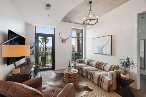a living room with furniture a lamp and a flat screen tv