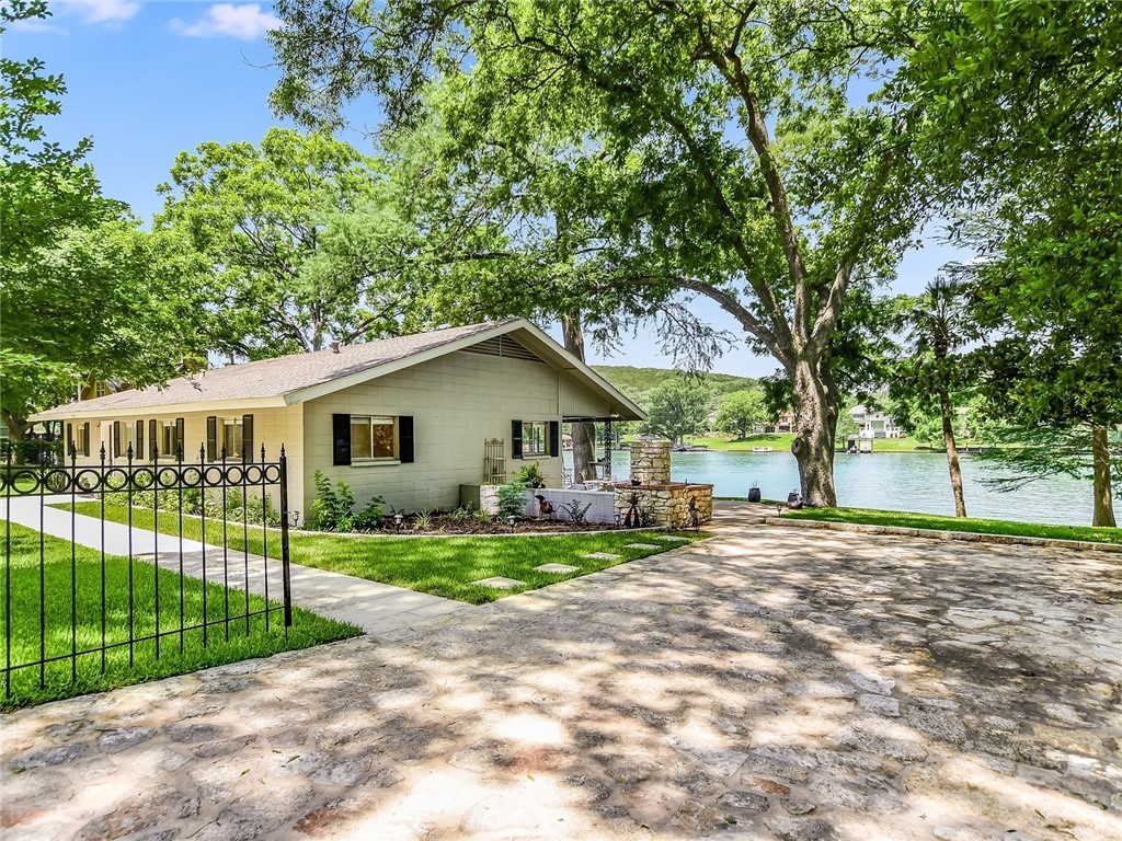 a view of a house with a big yard and large trees