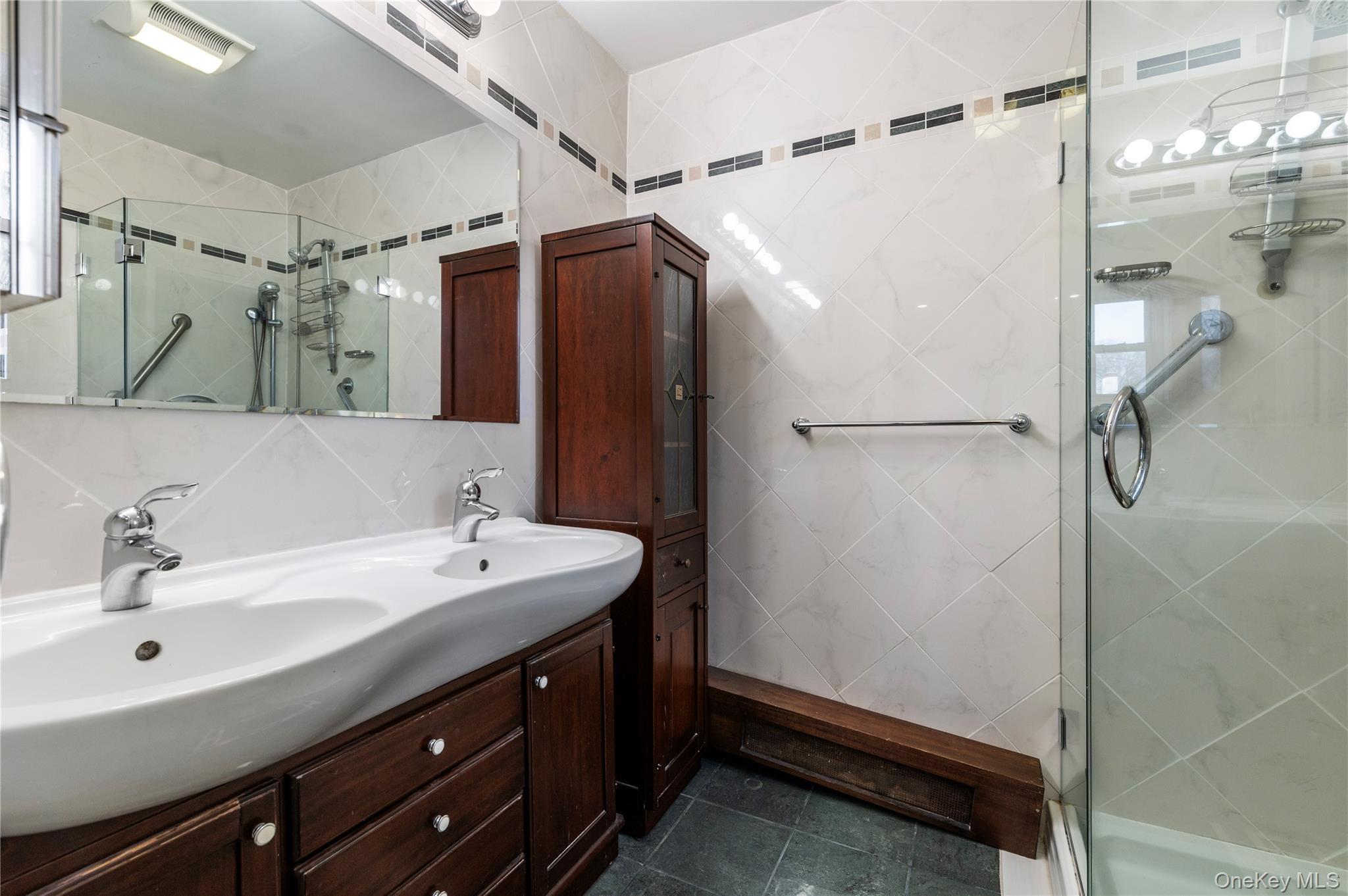 25 Chapel Place, Unit 2L Great Neck, NY 11021 - Photo 18 of 25 a bathroom with a double vanity sink mirror and shower
