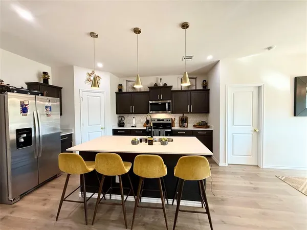 a kitchen with stainless steel appliances a stove refrigerator sink and cabinets