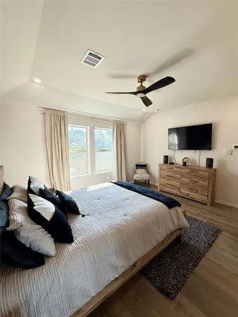 a bedroom with bed tv and window