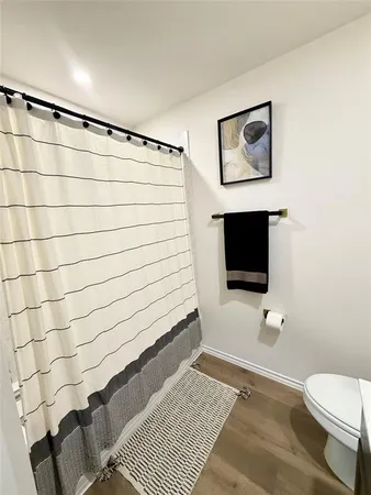 a bathroom with a toilet and a flat screen tv