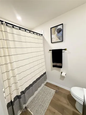 a bathroom with a toilet and a flat screen tv