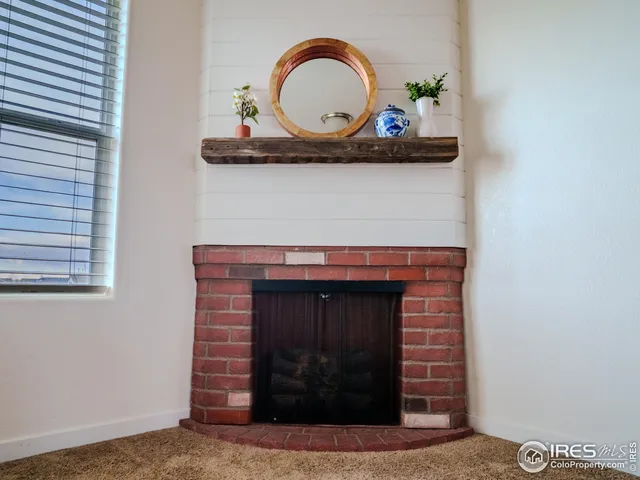 a fireplace with a vase of flowers on it and vanity