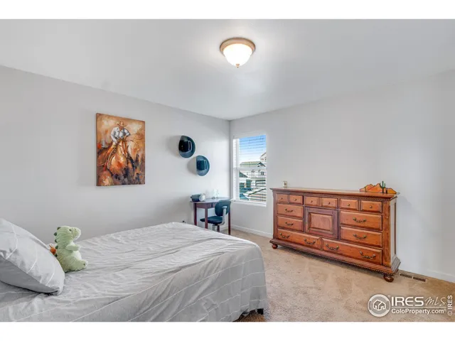 a bedroom with a bed and a painting on the wall