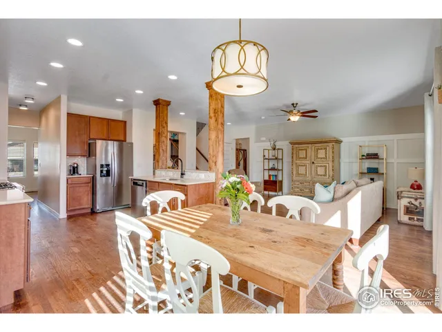 a room with stainless steel appliances kitchen island granite countertop a table and chairs in it