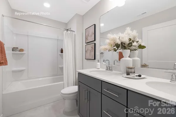 a bathroom with a granite countertop sink a toilet and shower