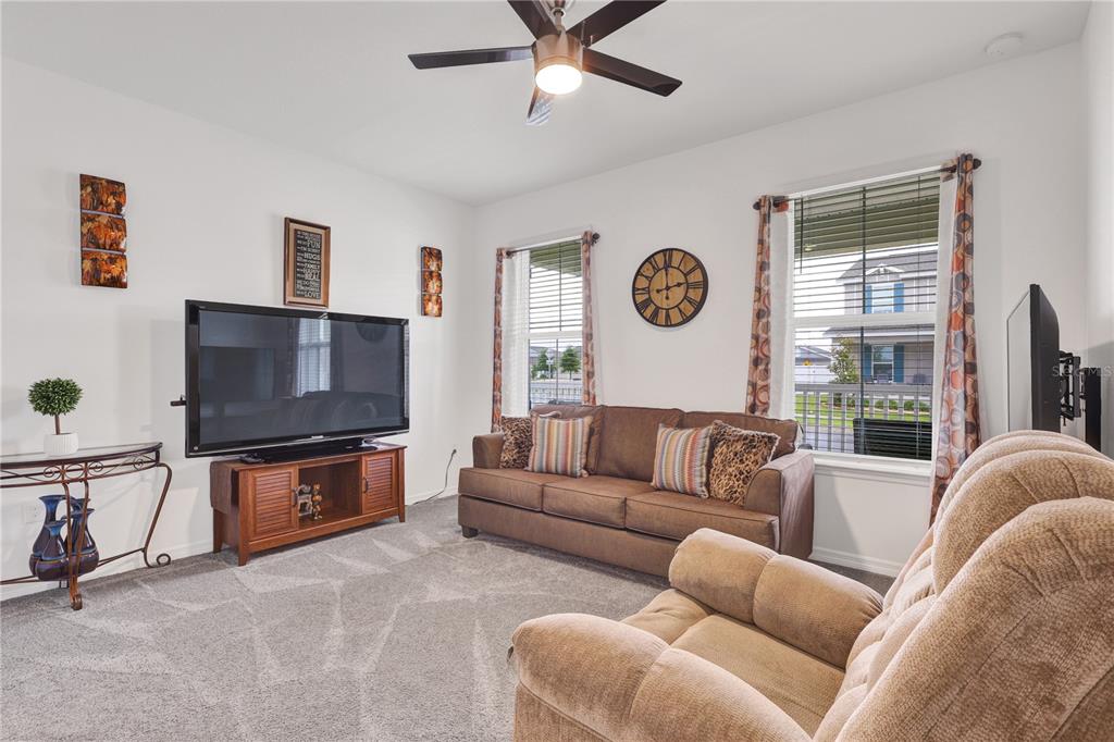 7185 Southwest 63rd Street Ocala, FL 34474 - Photo 24 of 31 a living room with furniture a flat screen tv and a large window